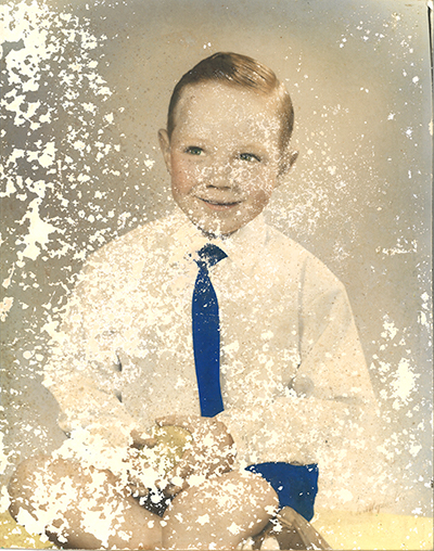 A tough restoration of old badly blemished photo of a small boy-ball